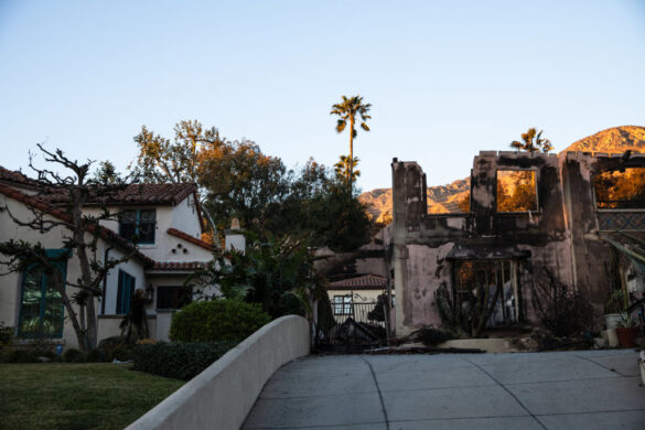 A home destroyed by the Eaton Fire is seen next to another left intact in Altadena, California