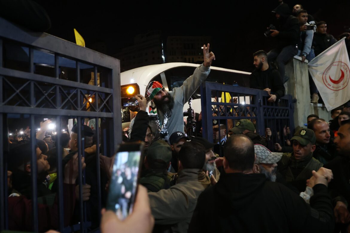 Un antiguo detenido palestino saluda a la multitud mientras llega tras ser liberado de prisión. EFE