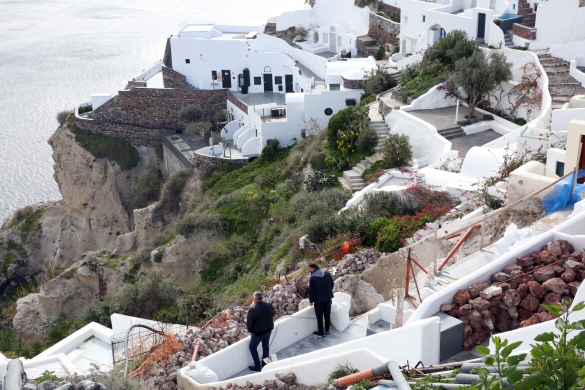 La gente examina su propiedad en el pueblo casi evacuado de Oia en la isla de Santorini, Grecia. EFE