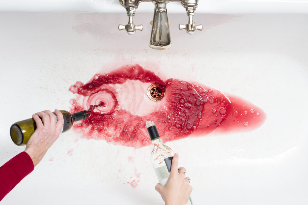 Pouring away wine in an act of giving up alcohol