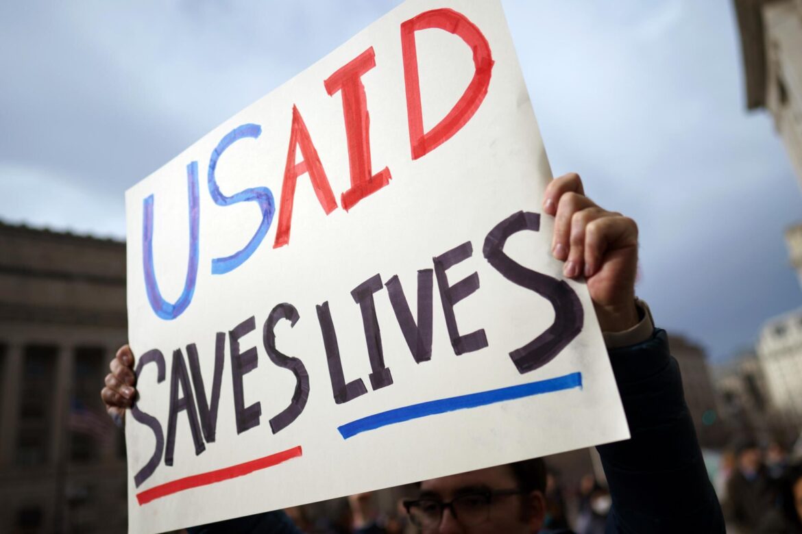Un manifestante sostiene un cartel frente a la Agencia de Estados Unidos para el Desarrollo Internacional (USAID) en Washington, DC. EFE