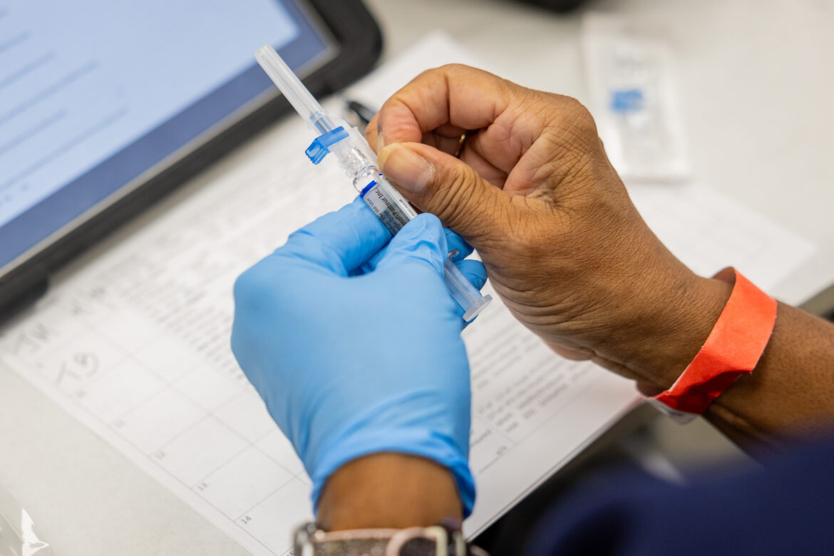 A nurse prepares to give a flu shot.
