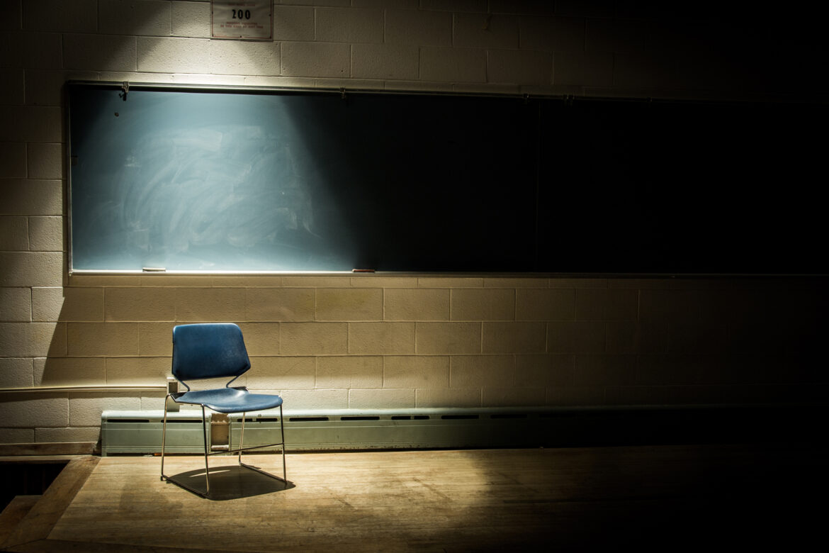 An Empty School Chair in a Dark Classroom