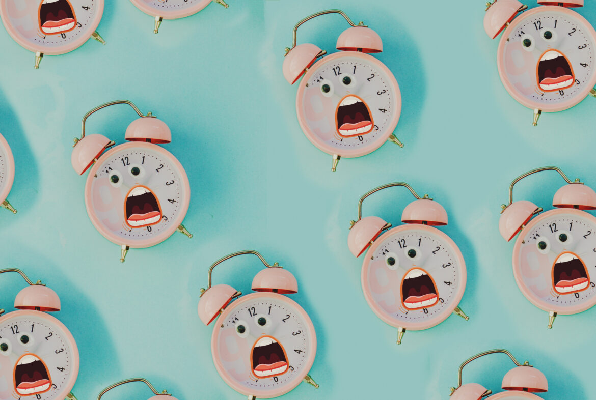 pink alarm clock in pastel colorful background.Top view